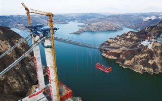 主跨达555米！世界最大跨度回转缆悬索桥首节钢桁梁吊装成功！
